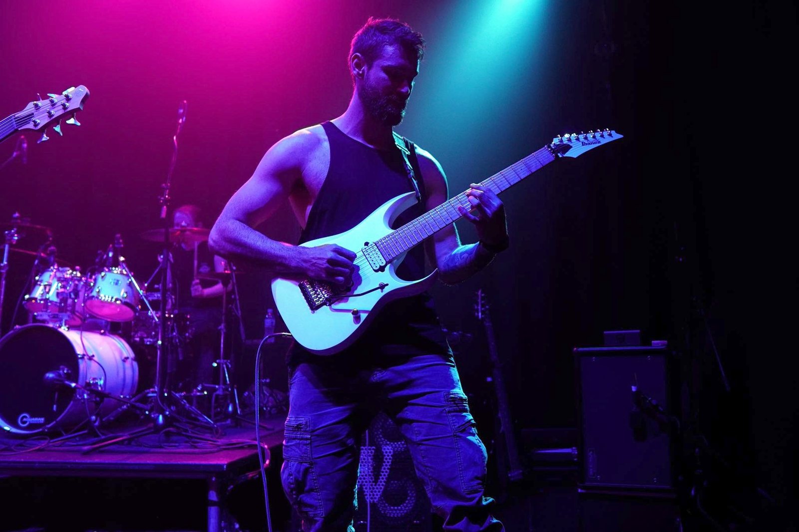 Joe Macedo playing electric guitar on stage